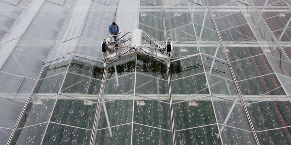 Washing and coating machine spray coating on roof of horticultural greenhouse